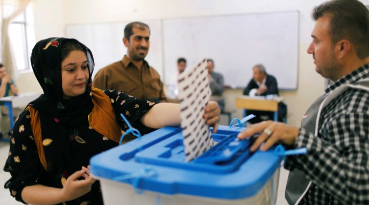 A Kurdish woman casts her vote at a polling station, during parliamentary elections in the semi-autonomous region in Erbil