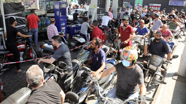 Motorbike drivers wait to get fuel at a gas station in Dora